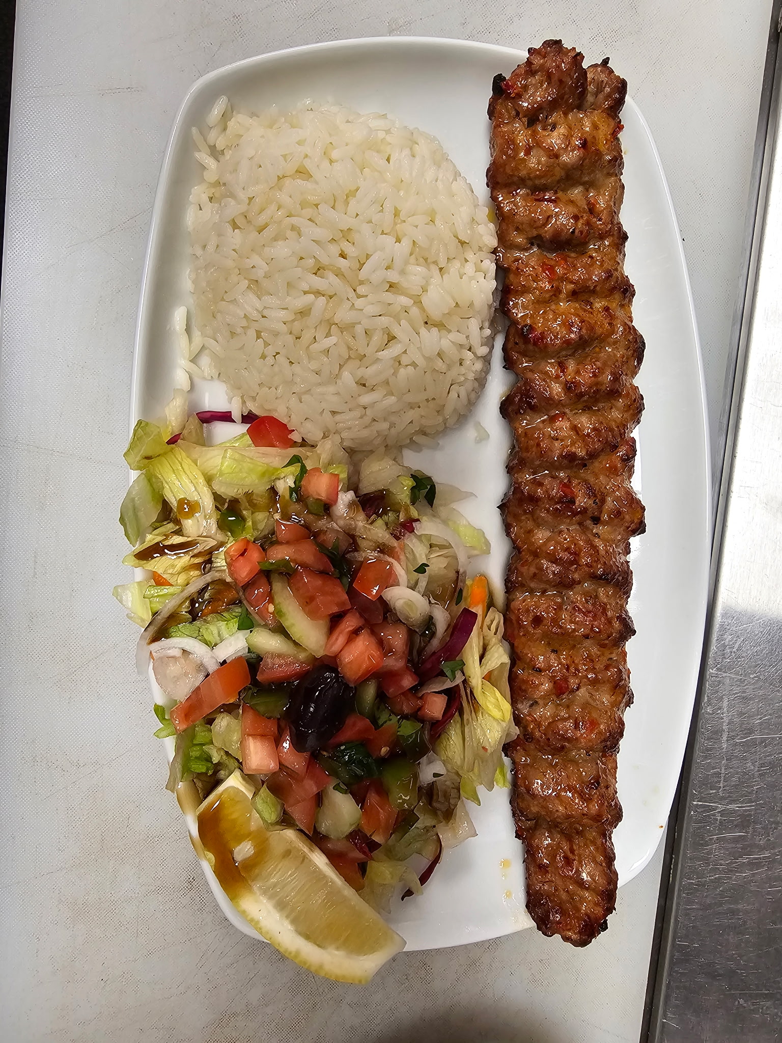 Adana kebab overhead with rice and fresh salad