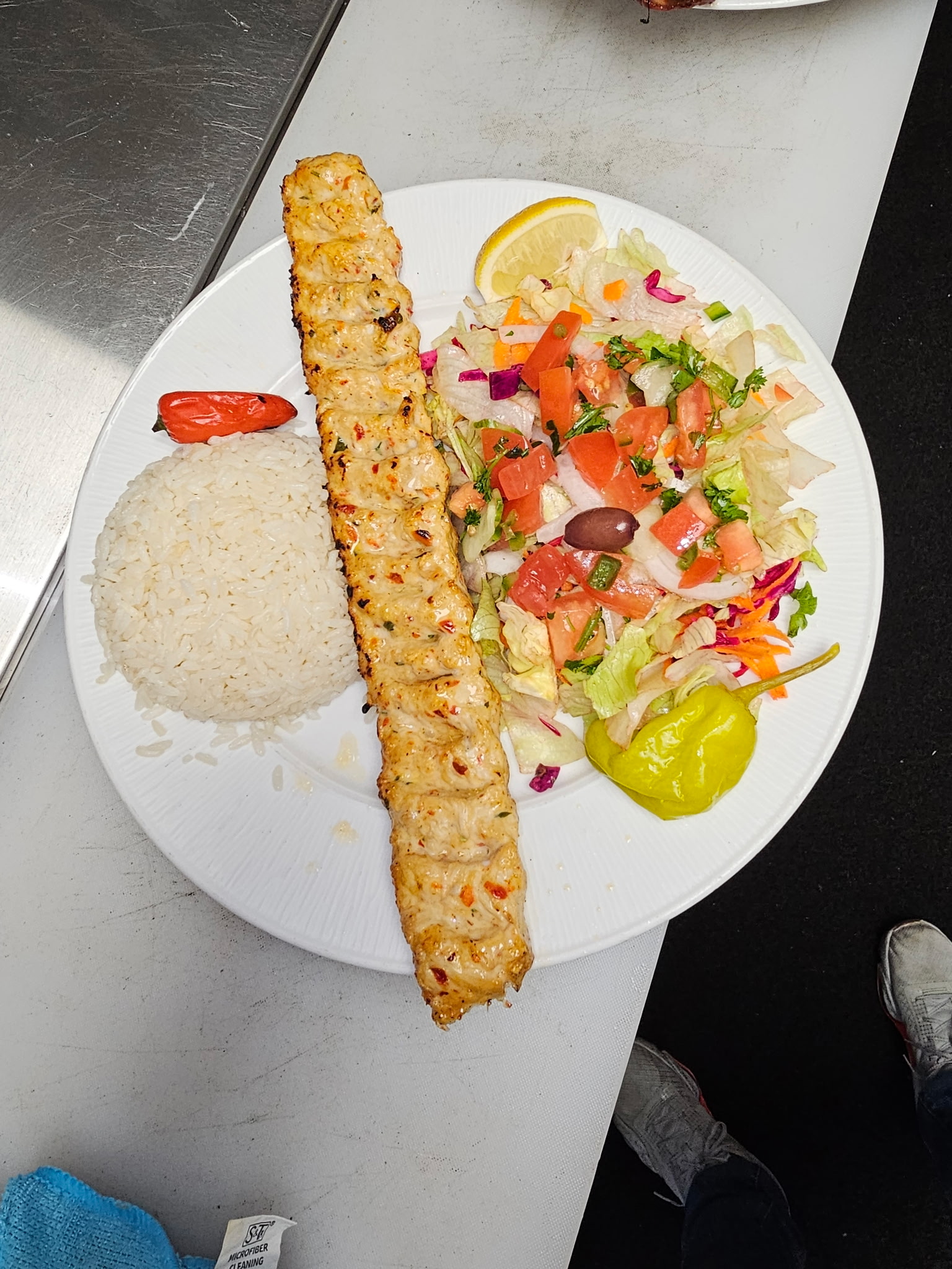 Chicken Adana kebab with rice, salad and pickled pepper
