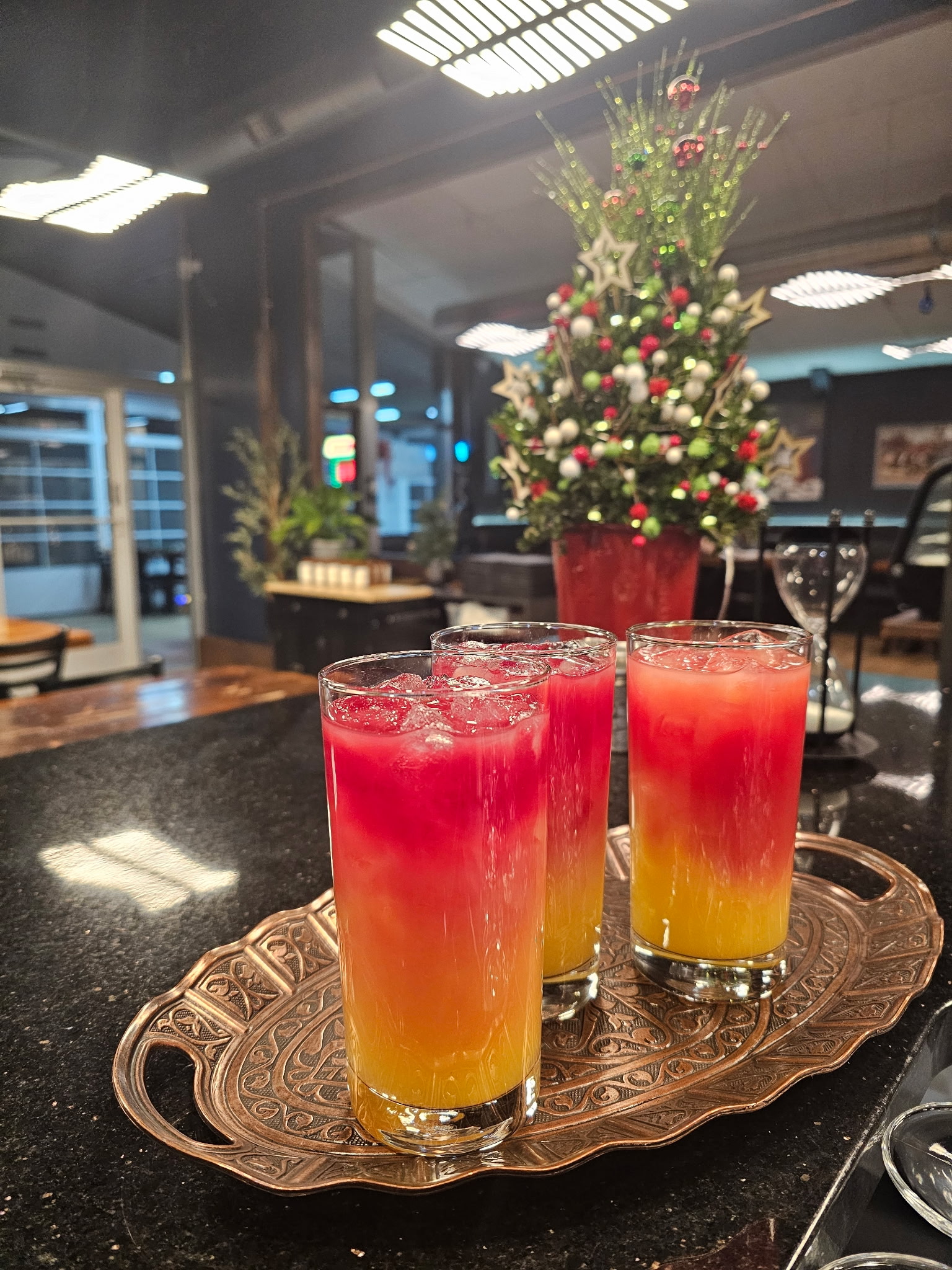 Three sunset cocktails on an ornate silver tray