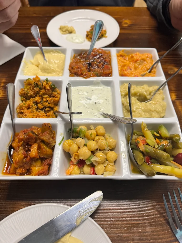 Nine-compartment mezze platter with hummus, cacik, baba ganoush, chickpeas and more