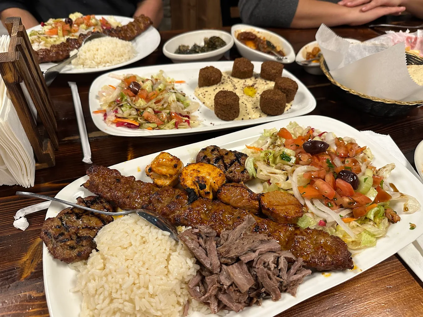 Full table spread of mixed kebabs, falafel and salads