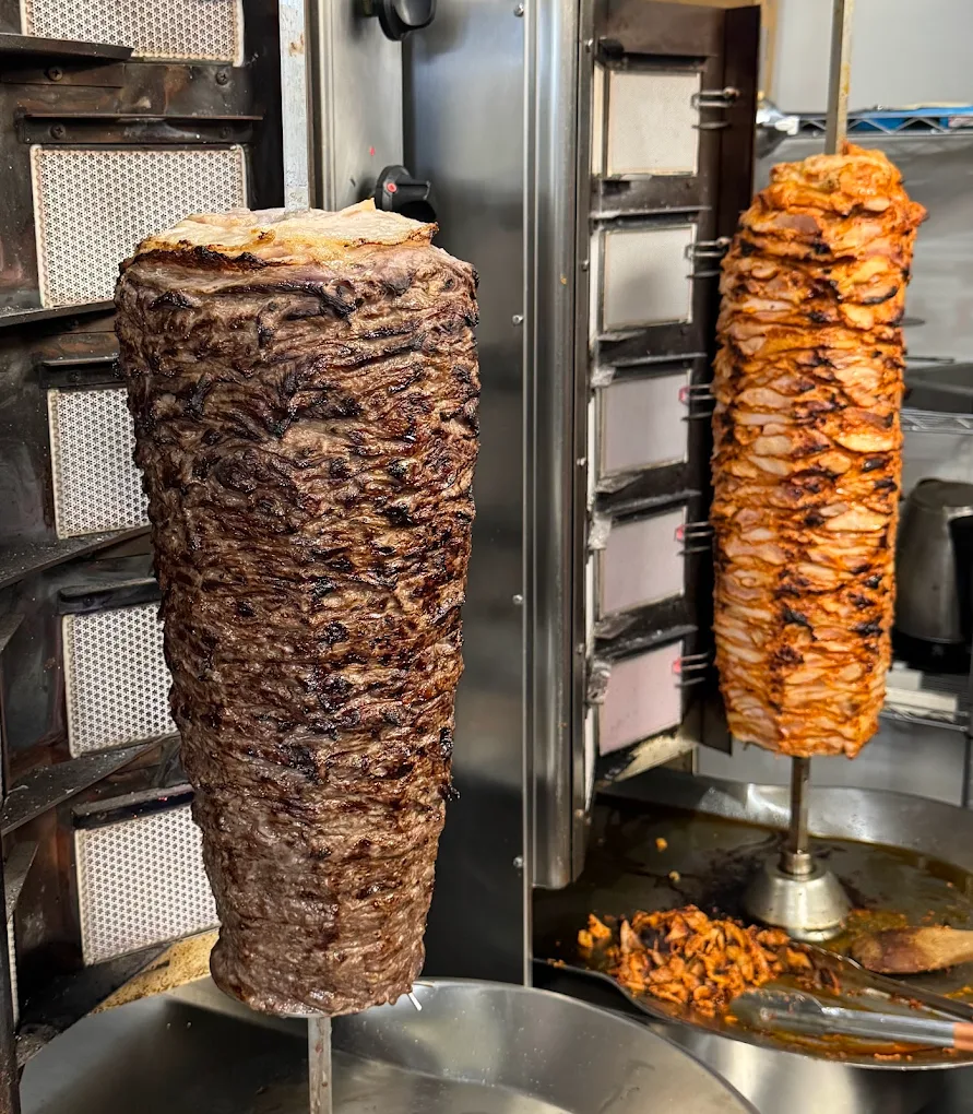 Lamb and chicken doner rotating on vertical rotisserie spits