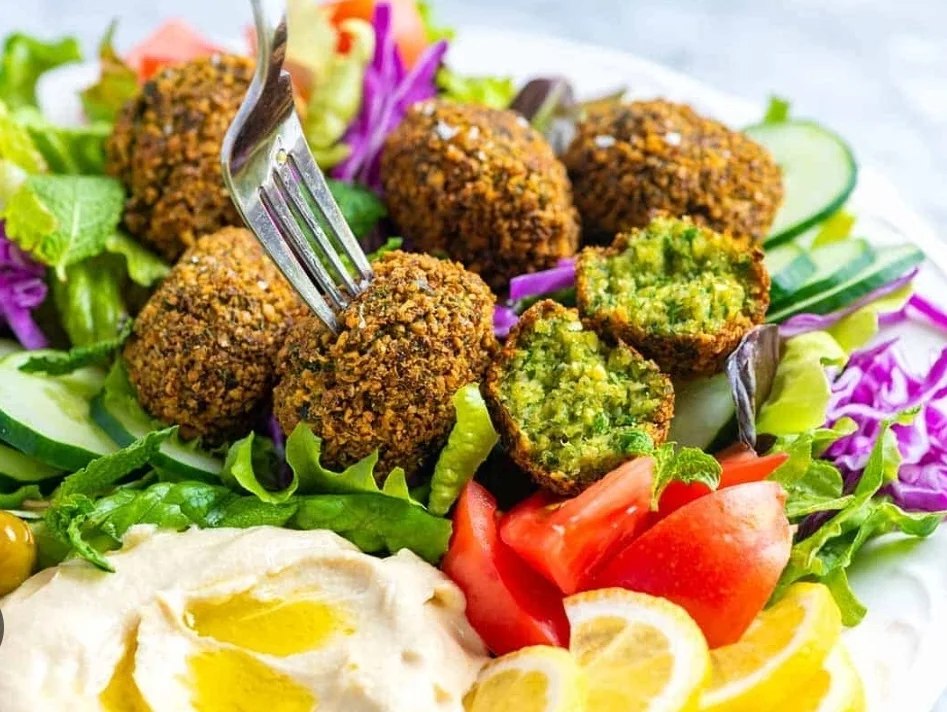 Golden falafel with hummus, fresh vegetables and lemon