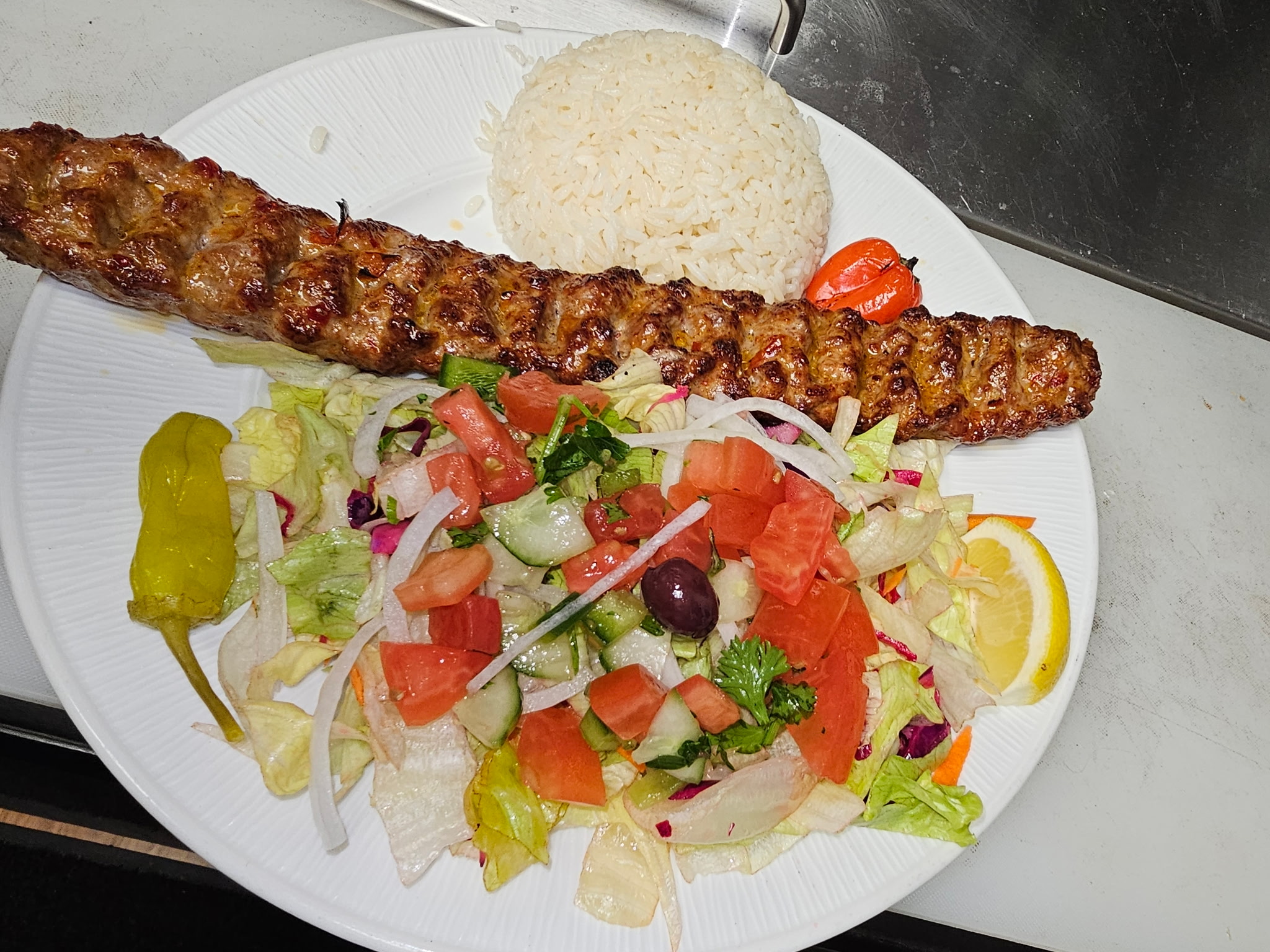 Charcoal-grilled kebab with rice and house salad